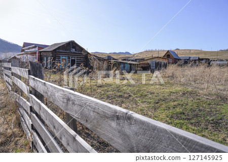 A street with an abandoned dilapidated house with antique window frames in Gorny Altai A street with an abandoned dilapidated house with antique window frames in Gorny Altai 127145925
