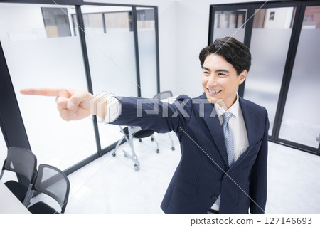 一個穿著西裝的男人指著目標、成功、成功等的商業場景。正面的詞語，如未來的成功和希望 127146693