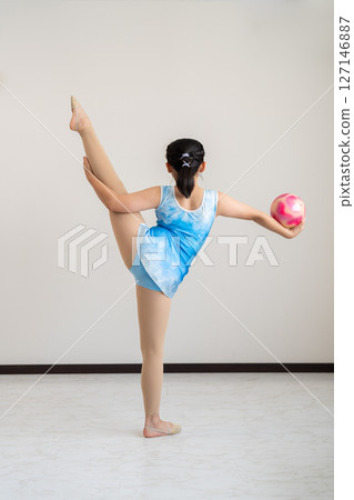 一個活潑的女孩嘗試體操的背影 127146887