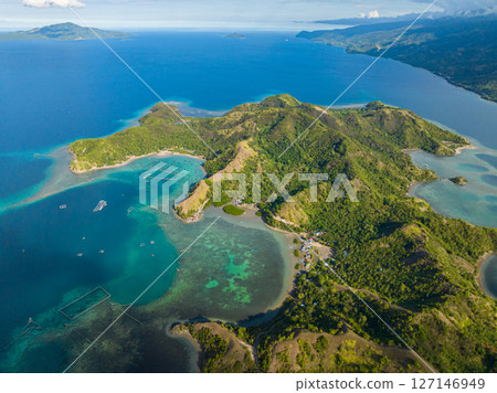 Tropical island surrounded azure water atoll and coral reefs. Sleeping Dinosaur Island. Mati, Davao Oriental. Philippines. 127146949