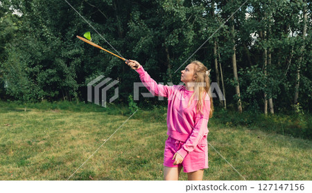 Young woman playing with Wooden badminton rackets and shuttlecocks concept. Copy space Summer outdoor activities. Staycation leisure Young woman playing with Wooden badminton rackets and shuttlecocks concept. Copy space Summer outdoor activities. Staycation leisure 127147156