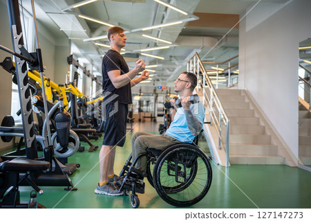 Coach guides disabled athlete through weightlifting workout focusing on technique and execution 127147273