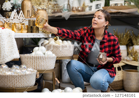 Festive young woman choosing christmas candles 127148101