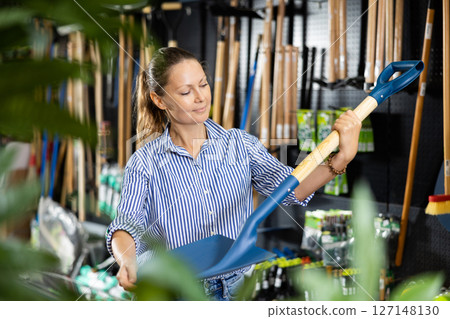 Positive woman purchasing new spade in shop 127148130