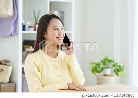 一位年輕女子在客廳打電話 一位年輕女子在客廳打電話 127148695