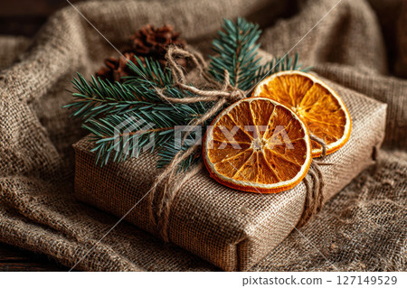 Handmade Christmas gift with jute rope, citrus slice and pine sprig 127149529