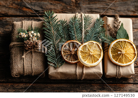 Handmade Christmas gift with jute rope, citrus slice and pine sprig 127149530