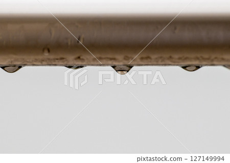 被雨水打濕的棍子上滴下的水滴 127149994