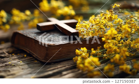 Cross of Jesus and holy bible surrounded by vibrant yellow flowers in a serene worship atmosphere 127150387