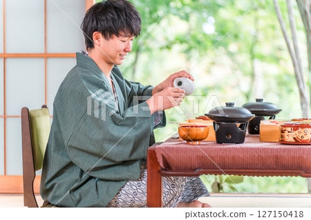 Young Asian man enjoying kaiseki cuisine at a ryokan (room service, kaiseki cuisine, gozen, luxury) 127150418
