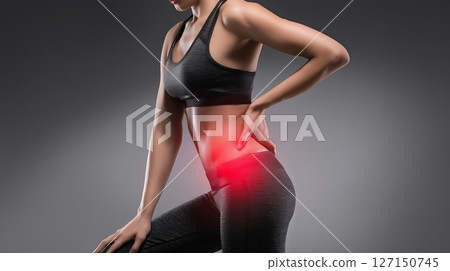 Woman experiencing lower back pain with discomfort radiating to legs, suggesting possible sciatica condition 127150745