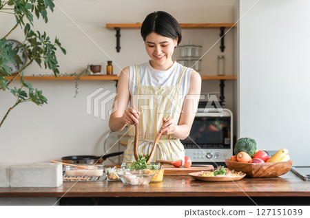 Young Asian woman cooking in the kitchen (cooking, home cooking) Young Asian woman cooking in the kitchen (cooking, home cooking) 127151039