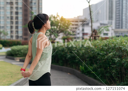 Asian woman fitness yoga workout. stretching exercise reduces shoulder pain muscle strain inflammation injury risk for medical wellness and healthcare in an urban city at sunset Asian woman fitness yoga workout. stretching exercise reduces shoulder pain muscle strain inflammation injury risk for medical wellness and healthcare in an urban city at sunset 127151074