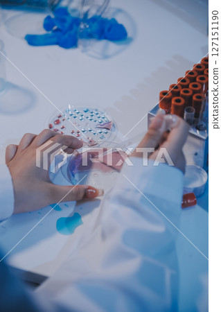 Research, experiment and medical trial being done by a scientist in a lab, science facility or hospital. One young, serious and professional researcher organizing, sorting or making a discovery 127151190