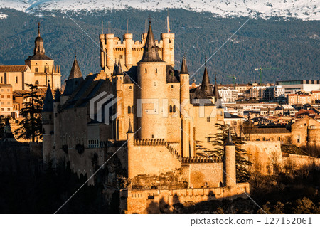 The Alcazar of Segovia stands majestically against the Guadarrama mountains in Spain. 127152061