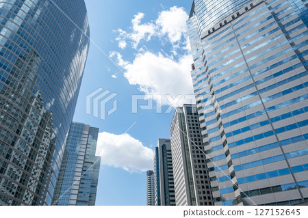 摩天大樓映襯著藍天,窗戶上倒映著雲彩 摩天大樓映襯著藍天,窗戶上倒映著雲彩 127152645