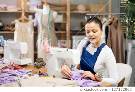 Female mechanic fixing sewing machine 127152963