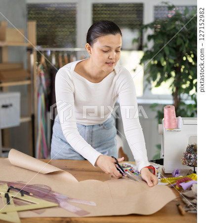 Asian dressmaker cutting paper in workshop Asian dressmaker cutting paper in workshop 127152982
