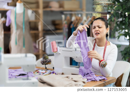 Asian dressmaker working with fabric 127153005