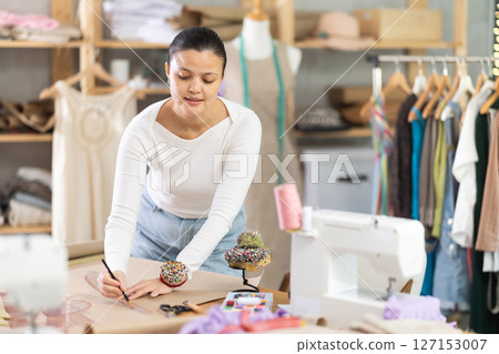 Asian dressmaker draws patterns with curved rulers 127153007