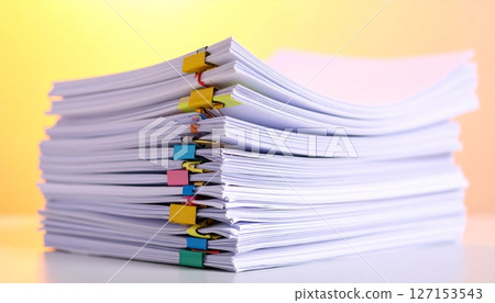 A vibrant pile of notebooks, colorful papers, and a pen represents a heap of business and education documents 127153543
