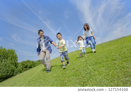 一家四口在公園的小山上玩耍 一家四口在公園的小山上玩耍 127154108