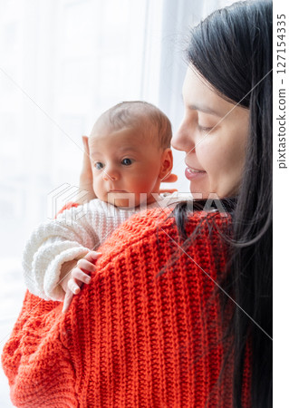 Tender Moment Between Mother and Baby by the Window Tender Moment Between Mother and Baby by the Window 127154335