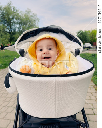 Smiling Baby in Yellow Hoodie in Stroller Smiling Baby in Yellow Hoodie in Stroller 127154345