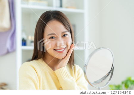 Young woman beauty looking in the mirror 127154348