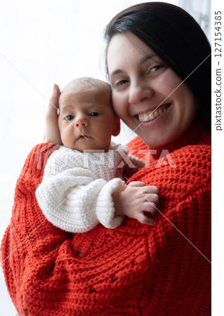 Tender Moment Between Mother and Baby by the Window 127154385
