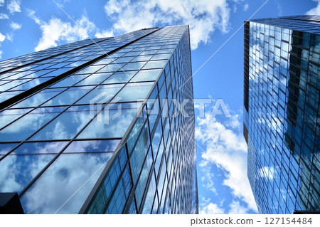 Modern sustainable glass office buildings. Exterior view of corporate headquarters glass buildings architecture.Glass windows in energy-efficient buildings. Financial business center buildings. Modern sustainable glass office buildings. Exterior view of corporate headquarters glass buildings architecture.Glass windows in energy-efficient buildings. Financial business center buildings. 127154484