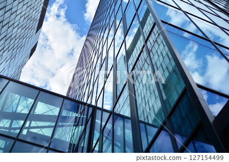 Modern sustainable glass office buildings. Exterior view of corporate headquarters glass buildings architecture.Glass windows in energy-efficient buildings. Financial business center buildings.  127154499