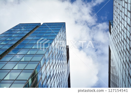 Modern sustainable glass office buildings. Exterior view of corporate headquarters glass buildings architecture.Glass windows in energy-efficient buildings. Financial business center buildings. Modern sustainable glass office buildings. Exterior view of corporate headquarters glass buildings architecture.Glass windows in energy-efficient buildings. Financial business center buildings. 127154541