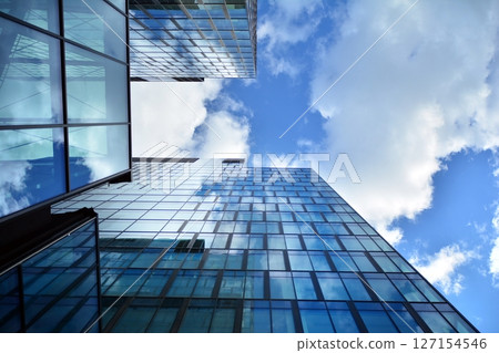 Modern sustainable glass office buildings. Exterior view of corporate headquarters glass buildings architecture.Glass windows in energy-efficient buildings. Financial business center buildings. Modern sustainable glass office buildings. Exterior view of corporate headquarters glass buildings architecture.Glass windows in energy-efficient buildings. Financial business center buildings. 127154546