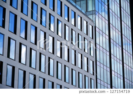 Modern sustainable glass office buildings. Exterior view of corporate headquarters glass buildings architecture.Glass windows in energy-efficient buildings. Financial business center buildings.  127154719