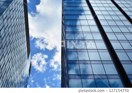 Modern sustainable glass office buildings. Exterior view of corporate headquarters glass buildings architecture.Glass windows in energy-efficient buildings. Financial business center buildings.  127154750