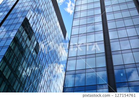 Modern sustainable glass office buildings. Exterior view of corporate headquarters glass buildings architecture.Glass windows in energy-efficient buildings. Financial business center buildings.  127154761