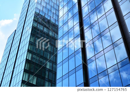 Modern sustainable glass office buildings. Exterior view of corporate headquarters glass buildings architecture.Glass windows in energy-efficient buildings. Financial business center buildings. Modern sustainable glass office buildings. Exterior view of corporate headquarters glass buildings architecture.Glass windows in energy-efficient buildings. Financial business center buildings. 127154765