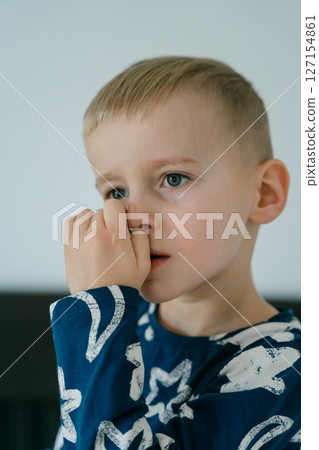 a little blond-haired boy in blue pajamas in his parents' bed lounging in the white sheets. High quality photo a little blond-haired boy in blue pajamas in his parents' bed lounging in the white sheets. High quality photo 127154861