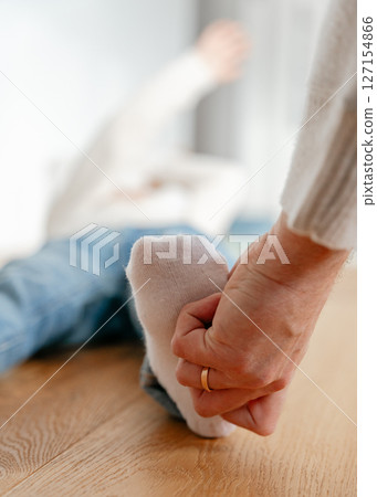 A dad holds his 4-year-old son's feet in his socks and tickles them. High quality photo 127154866