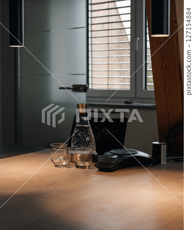 office desk of the chief of staff with two lamps hanging from the top and a bottle of water and two glass glasses on the desk. High quality photo office desk of the chief of staff with two lamps hanging from the top and a bottle of water and two glass glasses on the desk. High quality photo 127154884