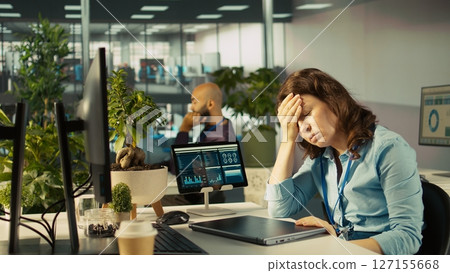 Accountant in busy modern startup agency imputing financial figures on PC after checking reports. Focused businesswoman working in modern office, crosschecking data, camera B Accountant in busy modern startup agency imputing financial figures on PC after checking reports. Focused businesswoman working in modern office, crosschecking data, camera B 127155668