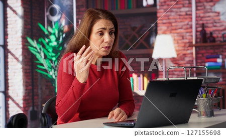 Displeased angry team leader yelling at her employees on web conference, attending an online video call meeting for briefing and getting irritated of careless workers. Impatience. Camera A. 127155698