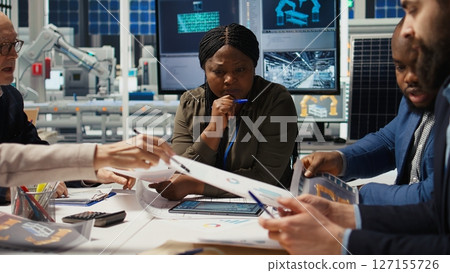 Solar panels plant shareholders chat about company growth and market expansion, analyzing paperwork. Investors meet with photovoltaics factory management executives to improve production, camera A Solar panels plant shareholders chat about company growth and market expansion, analyzing paperwork. Investors meet with photovoltaics factory management executives to improve production, camera A 127155726