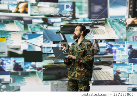 Officer monitoring real time combat data using advanced military systems, cyber tactics and digital surveillance to ensure battlefield control and strategic defense. War planning. 127155905