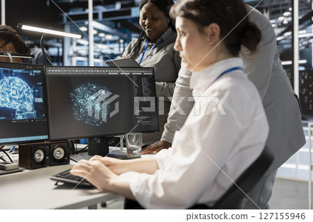 Data center team of programmers using artificial intelligence neural networks technology. Server farm coworkers using AI programming language on computer to update equipment Data center team of programmers using artificial intelligence neural networks technology. Server farm coworkers using AI programming language on computer to update equipment 127155946