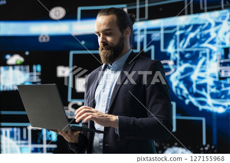 Entrepreneur uses laptop to review artificial intelligence brain system on dashboards, using high tech data visualization for coding, analytics and machine learning. Strategic development. Entrepreneur uses laptop to review artificial intelligence brain system on dashboards, using high tech data visualization for coding, analytics and machine learning. Strategic development. 127155968