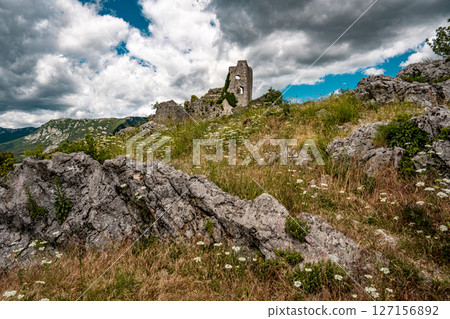 Ruins Of Grad Vipava In Slovenia: Ancient Stone Walls Covered In Ivy Standing On A Grassy Hilltop Under A Dramatic Cloud-Filled Sky In The Scenic Vipava Valley 127156892