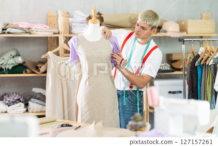 Young male tailor working with mannequin 127157261