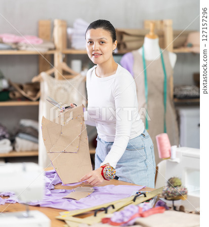 woman tailor holds patterns for clothes in her hands 127157296